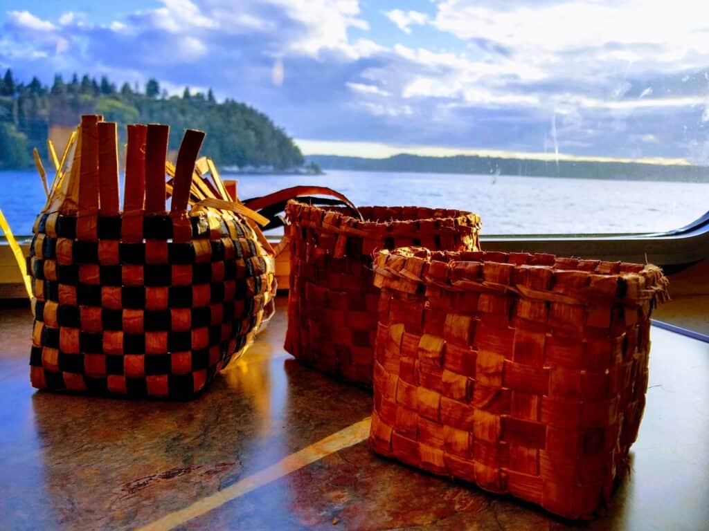 Two baskets on a table with a view of the water.