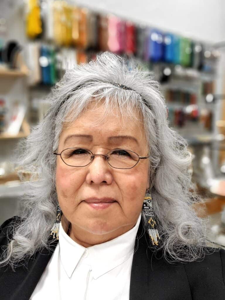 A woman with gray hair and glasses in a store.