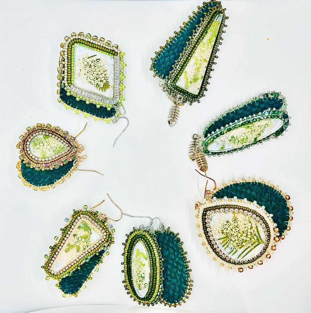 A group of earrings with green and white designs.