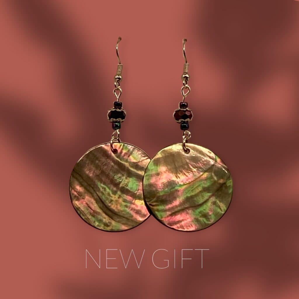 A pair of earrings with a iridescent shell and beads.