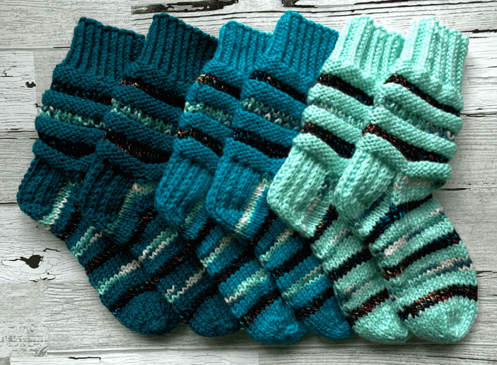 Three pairs of socks with blue, green and black stripes.