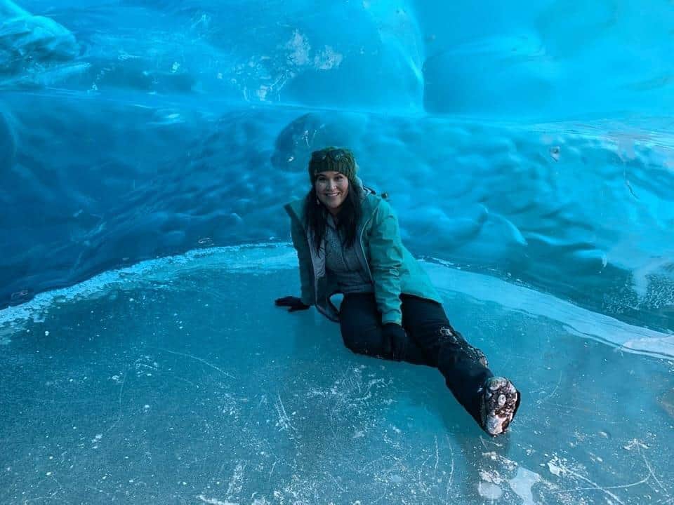 A photo of a woman sitting in front of a cold and watery background.
